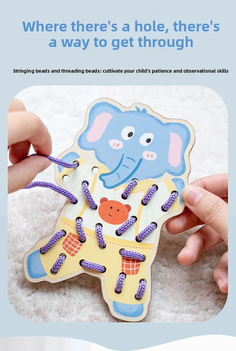 A hand is holding a wooden elephant lacing toy with purple beads and stringing threads on a soft, white surface.