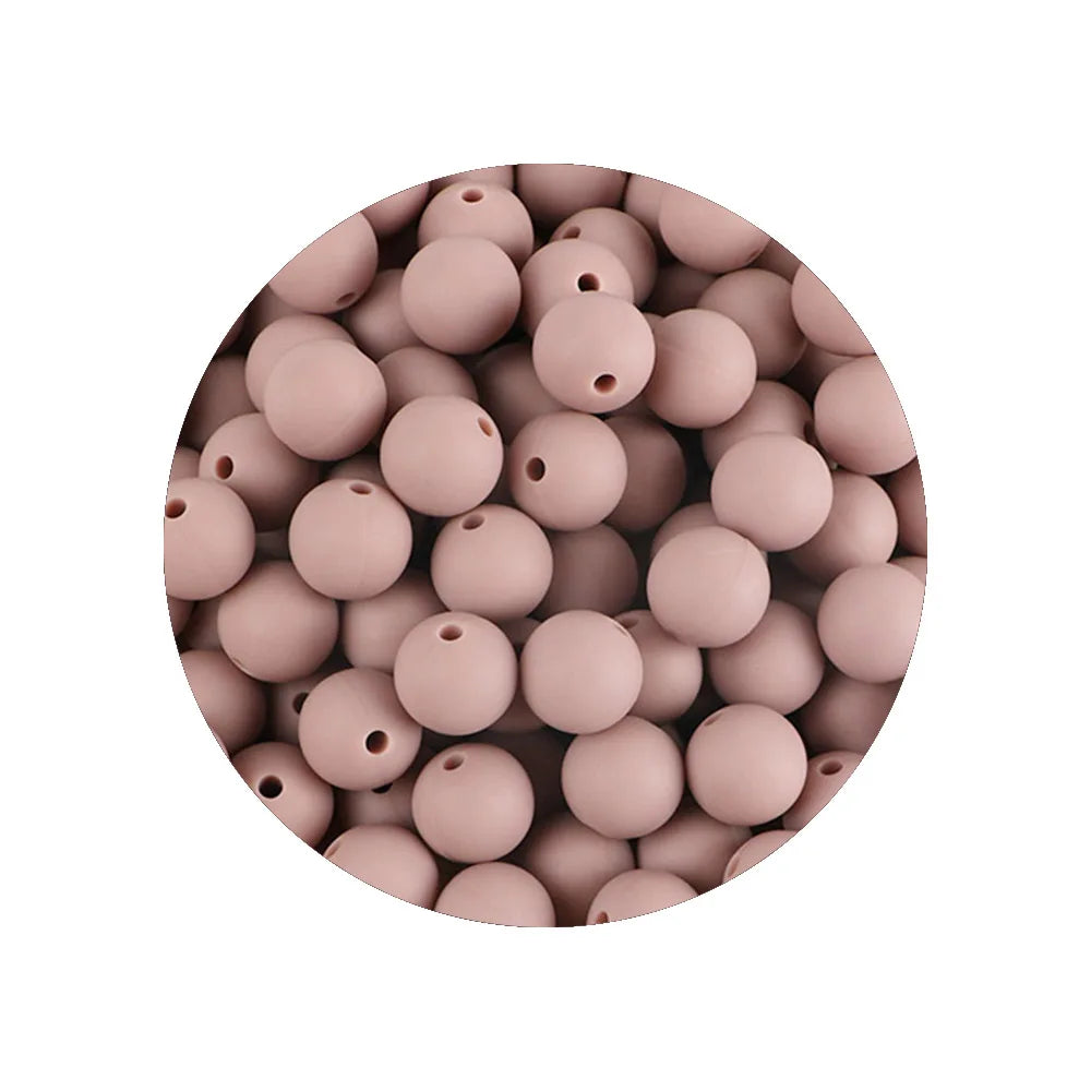 A circular arrangement of pink silicone beads in various sizes for DIY jewelry making