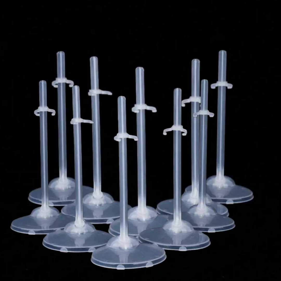 A set of transparent doll display stands with waist clips arranged against a black background.