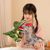 Une jeune fille tient un jouet de marionnette en peluche d'un dinosaure vert sur un fond clair.