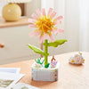 A building block set shaped like a pink and yellow rose flower with green leaves and small flowers.