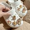 A hand holds a white shoe with multiple glow-in-the-dark capybara charms attached to the sole.