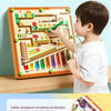 A young boy is using a wooden magnetic maze puzzle board to train color classification and improve concentration.