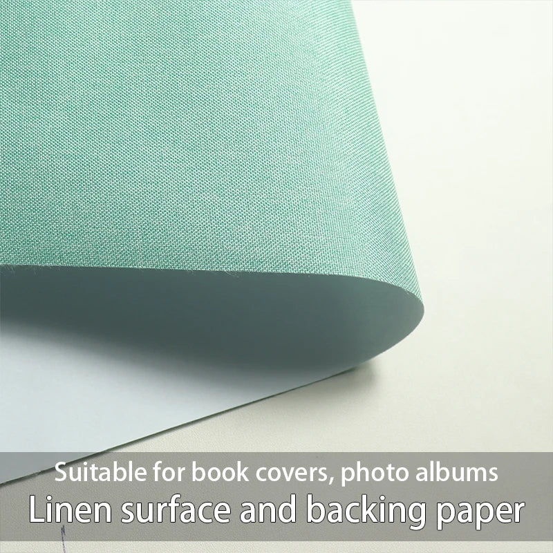 A close-up view of a light green linen surface and backing paper material.