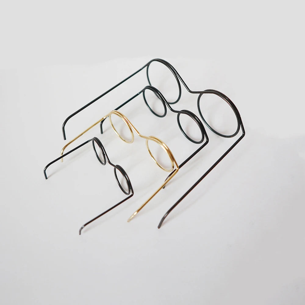 A collection of five metal round glasses frames, including black and gold options, displayed on a white background.