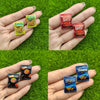 A hand holds several packages of Sun Chips and Lay's potato chips on a green surface.