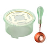 A clear container of wax is shown next to a green heater and a copper-colored spoon for an elegant wax seal melting kit.