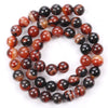 A circular arrangement of polished, reddish-brown and black natural sea sediment jasper and turquoise beads for jewelry makin