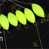 A row of bright yellow oval fishing floats with attached bobber beads are displayed against a dark background.