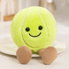 A bright lime green plush sports ball companion with small feet resting on a white plate.