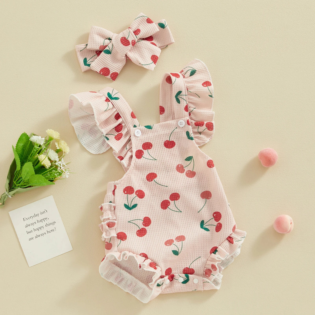 Pink baby girls summer romper set with matching bow and headband featuring a red cherry print