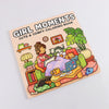 A colorful illustration of a girl with pets and cozy items on a coloring book cover titled Girl Moments.