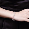 A close-up of a woman's wrist wearing an elegant sterling silver snake chain bracelet.