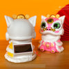A white solar-powered shaking head lion figurine with pink accents and a solar panel on its chest.