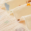 A close-up of soft, light yellow baby gauze swaddle blankets with subtle colorful patterns.