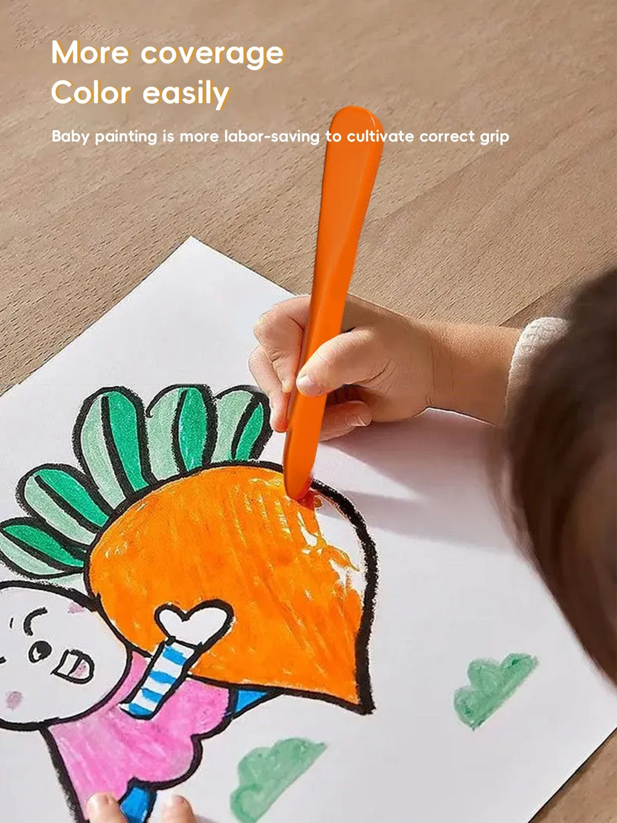 A child is using an orange crayon with a triangular grip to color a face on white paper.