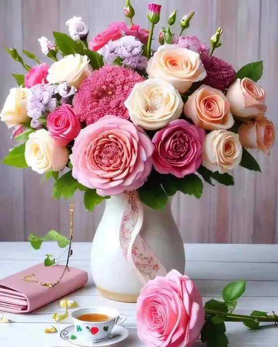 A vibrant bouquet of pink, peach, and purple roses and flowers arranged in a white vase.