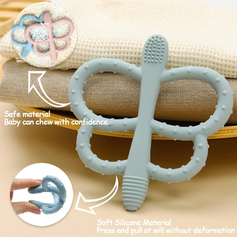 A light blue silicone butterfly teether is shown next to a rolled cloth, demonstrating its safe and durable material.