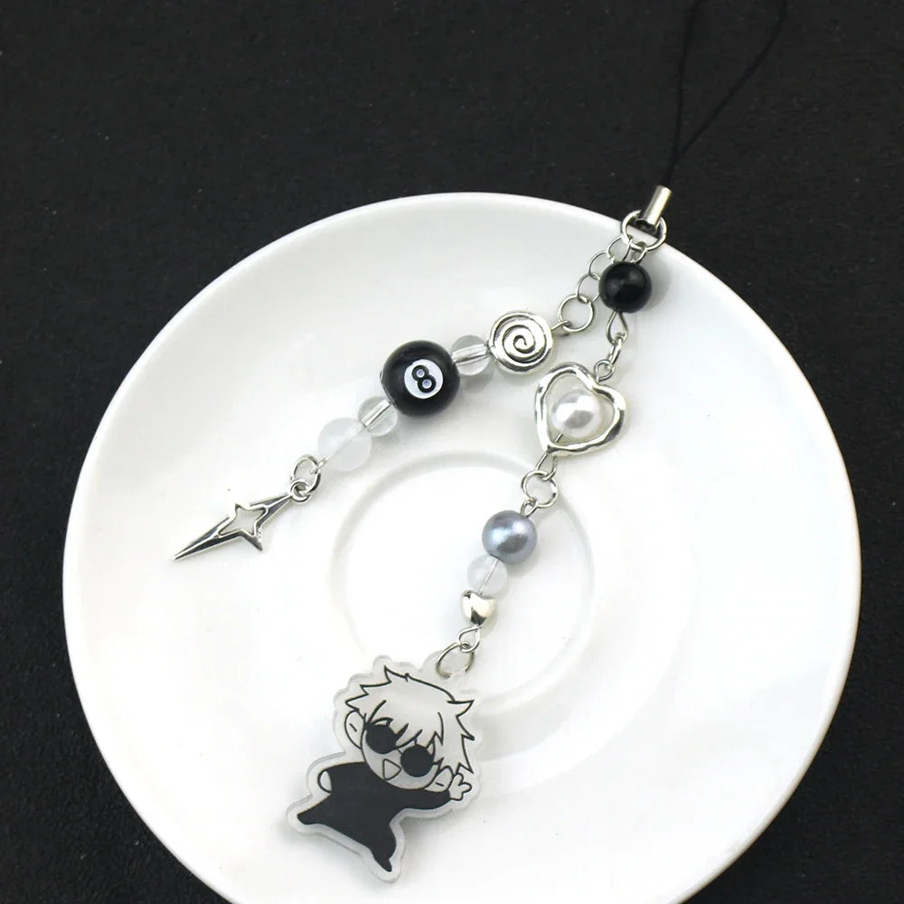 Silver and pearl keychain featuring a black charm shaped like an anime character.