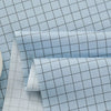 Light blue grid print fabric rolled and stacked for sewing and DIY crafts