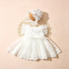 A white lace tulle dress for a newborn baby girl displayed on a light background with a matching lace hat.