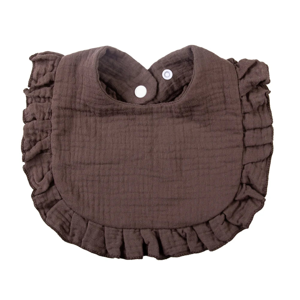 A dark brown ruffled muslin cotton baby bib with an adjustable snap closure.