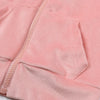 A close-up of a pink velvet tracksuit set featuring a hooded zipper coat and matching pants.