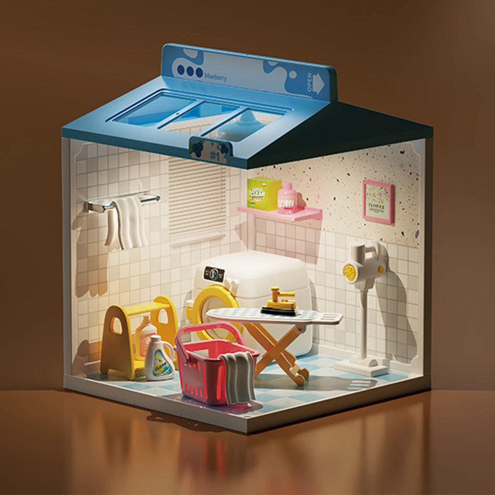 A miniature dollhouse display featuring furniture and accessories under a light box with a blueberry theme.