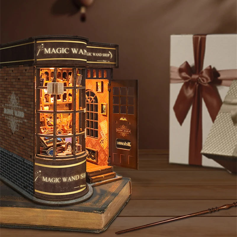 A wooden miniature kit of a magic wand shop display built into a book nook.