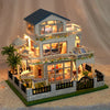 A detailed wooden mini seaside villa dollhouse kit featuring a two-story structure with furniture and landscaping.