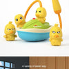A set of yellow duck bath toys with orange sprayers and a green water tray for kids