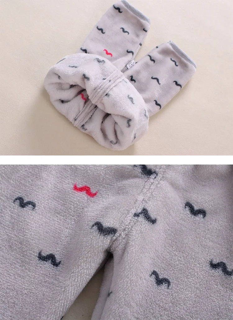 A gray fleece jacket and pants set for a baby with black mustache cartoon prints.