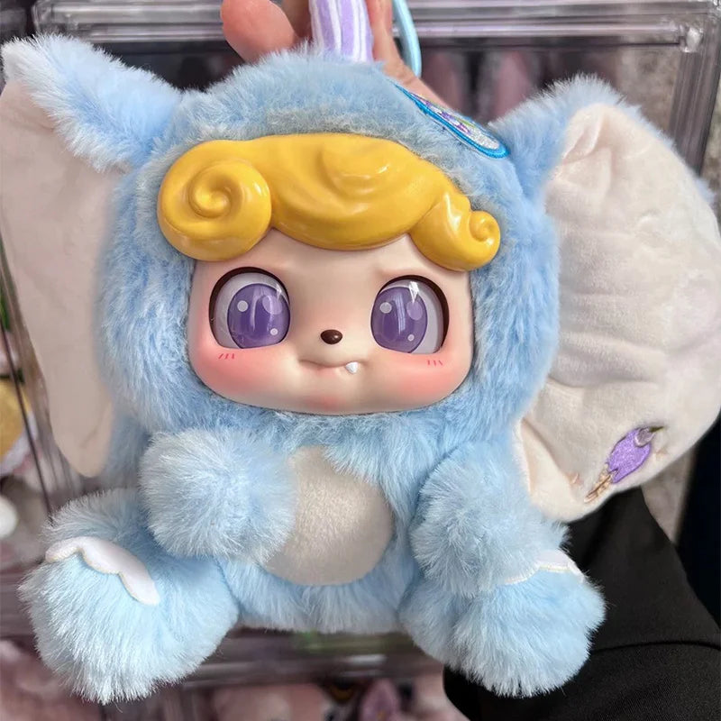 A soft blue plush collectible doll with yellow hair and large purple eyes.