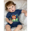 A baby doll wearing a navy blue t-shirt with an orange tiger design is posed on a white fluffy surface.