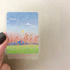 A decorative sticker pack featuring a watercolor landscape of a sunset over mountains and sea with yellow sun and pink sky.