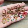 A set of six gold-toned metal keychains featuring character pendants from Stranger Things.