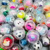 A close-up view of a pack of transparent plastic eggshell party favors filled with colorful, cute, character-themed items.