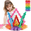 A young girl is building a colorful structure using Plum Blossom Snowflake building blocks.