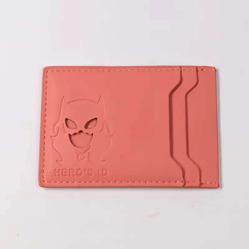 A pink leather card holder wallet featuring a cutout design of a superhero cat face.