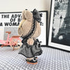 A fluffy, black and white flannel outfit for a 17cm Labubu doll is displayed in front of framed artwork.