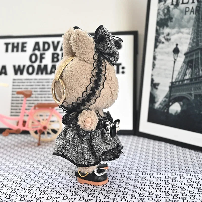 A fluffy, black and white flannel outfit for a 17cm Labubu doll is displayed in front of framed artwork.