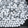 A pile of white mocha sparkling crystal flatback rhinestones for nail art and crafts.