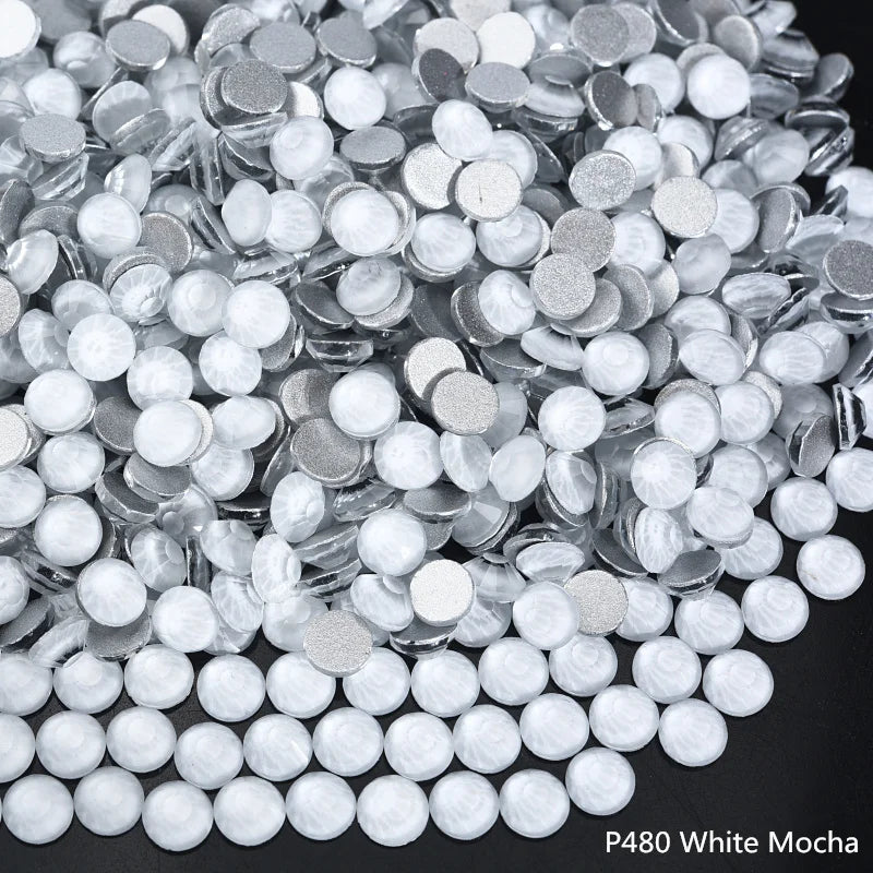 A pile of white mocha sparkling crystal flatback rhinestones for nail art and crafts.