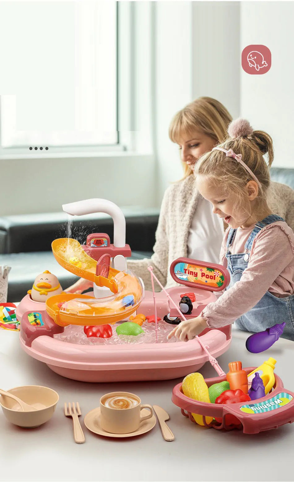 A young girl plays with an orange interactive kitchen sink toy featuring running water and a fishing game.