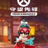 A collectible PVC figurine of a character in Overwatch attire, featuring red and white armor and green hair.