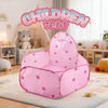 A pink foldable pop-up play tent for children sitting on a light rug in a bright room.