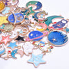 Assortment of gold-tone enamel charms featuring celestial shapes like moons, stars, and planets for jewelry making