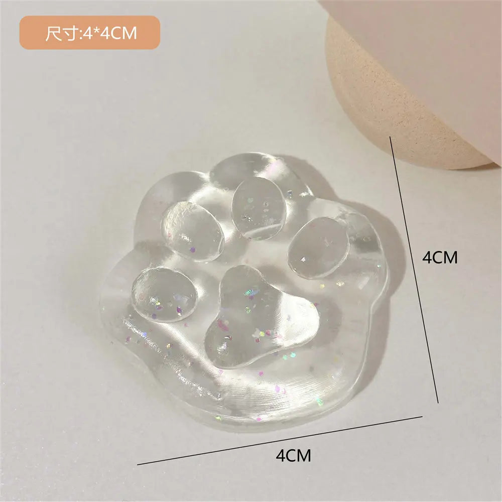 A clear, squishy cat paw shaped stress relief toy with multiple indentations and glitter inside.