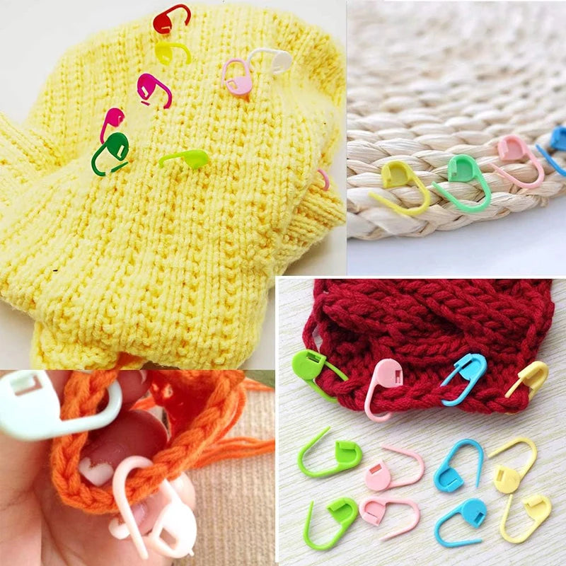 A collection of colorful locking stitch markers for knitting and crochet, including yellow, pink, green, and blue plastic rin