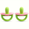 A pair of silicone teething rings with green and pink components shown against a white background.